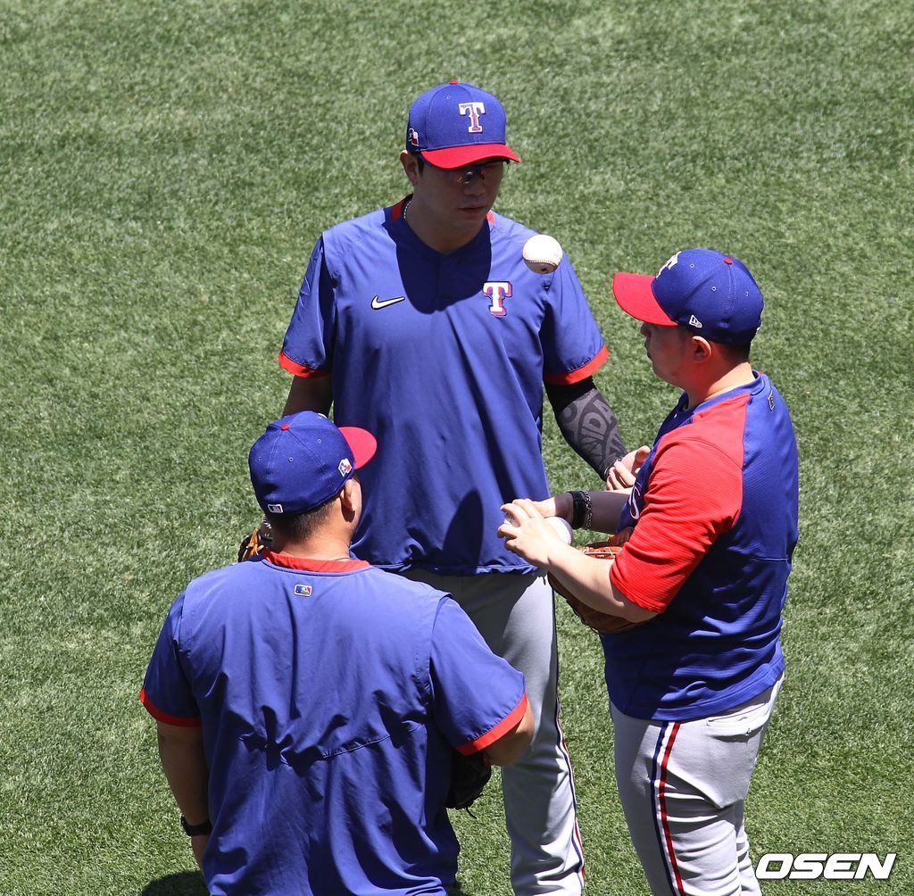 [OSEN=애너하임, 이사부 통신원] 텍사스 레인저스의 양현종이 27일(한국시간) 에인절 스타디움에서 벌어진 LA 에인절스와의 경기에 앞서 회복 훈련을 마친 뒤 그랜달 사가라 피칭 코치(등)와 대화를 나누고 있다. /lsboo@osen.co.kr