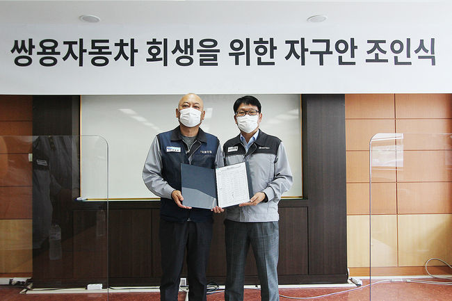 정용원 관리인(사진 오른쪽)과 정일권 노동조합 위원장이 합의안에 서명한 후 기념촬영을 하고 있다. 