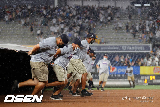 [사진] 뉴욕 양키스의 그라운드 스태프들이 1일(한국시간) LA 에인절스와의 경기 도중 비가 내리자 방수포를 펼치고 있다.ⓒGettyimages(무단전재 및 재배포 금지)