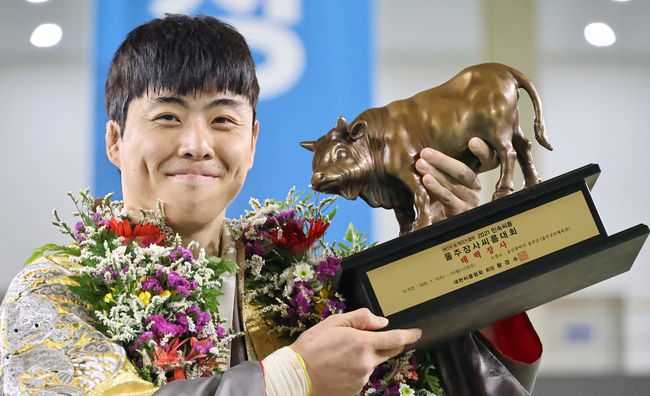 [사진] 8일 울산광역시 울주군 울주군민체육관에서 열린 ‘위더스제약 2021 민속씨름 울주장사씨름대회’ 태백장사(80kg이하)에 등극한 손광복(울주군청)이 황소트로피를 들고 환하게 웃고 있다./ 대한씨름협회 제공