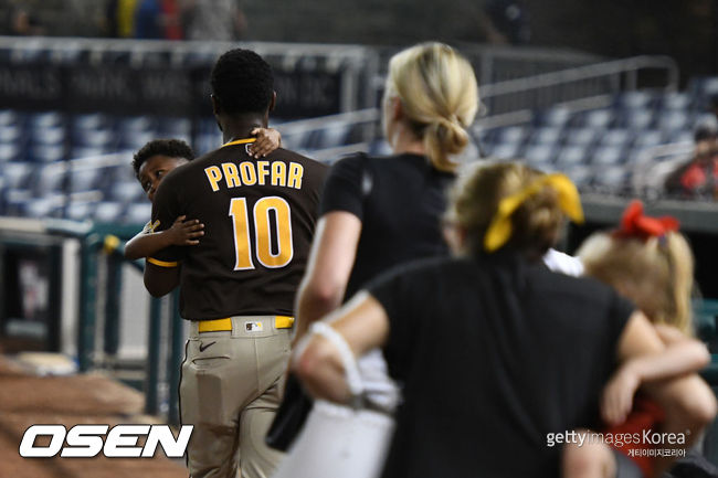 [사진] 샌디에이고의 트렌트 그리샴이 18일(한국시간) 총격사건으로 패닉이 된 내셔널즈 파크에서 자신의 아들을 데리고 덕아웃으로 향하고 있다.ⓒGettyimages(무단전재 및 재배포 금지)