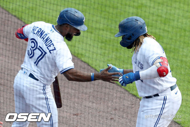 [사진] 토론토 블라디미르 게레로 주니어(오른쪽)가 2차전 2회 홈런을 치고 난 뒤 테오스카 에르난데스와 기뻐하고 있다. 2021.07.19 ⓒGettyimages(무단전재 및 재배포 금지)