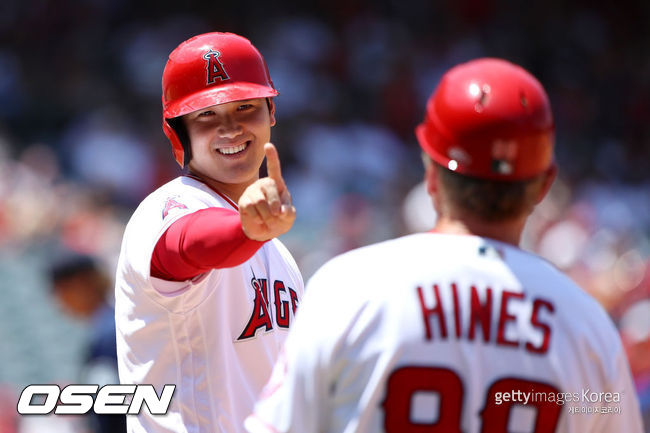 [사진] LA 에인절스의 오타니 쇼헤이가 19일(한국시간) 에이절스타디움에서 벌어진 시애틀 매리너스와의 홈경기에서 볼넷을 골라 1루로 진루한 뒤 브루스 하인스 1루 코치에게 손가락을 펴보이며 메시지를 전하고 있다. ⓒGettyimages(무단전재 및 재배포 금지)