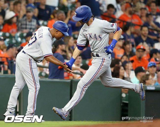 [사진] 텍사스의 일라이 화이트가 26일(한국시간) 미닛 메이드 파크에서 벌어진 휴스턴과의 경기 5회서 솔로 홈런을 날린 뒤 3루를 돌며 베이스 코치와 손을 마주치고 있다. ⓒGettyimages(무단전재 및 재배포 금지)
