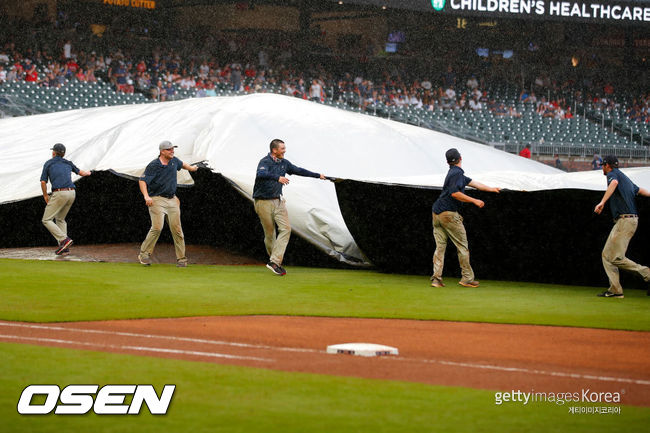 [사진] 지난 22일(한국시간) 샌디에이고와 애틀랜타의 더블헤더 2차전 도중 비가 쏟아지자 그라운드 크루들이 방수포를 덮고 있는 모습. ⓒGettyimages(무단전재 및 재배포 금지)