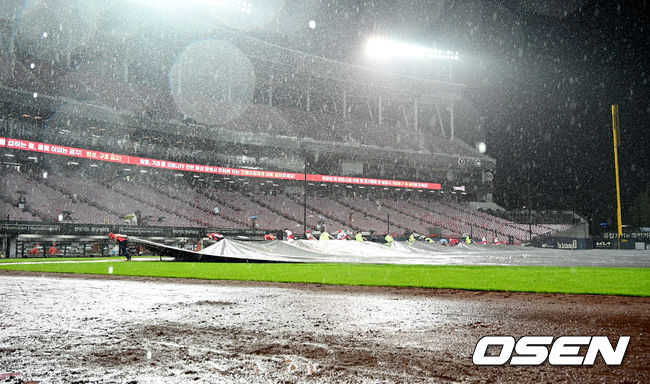 25일 광주-기아 챔피언스필드에서 ‘2021 신한은행 SOL KBO 리그’ KIA 타이거즈와 롯데 자이언츠의 경기가 열렸다. 3회말 2사 1,2루 갑작스럽게 내린 비로 경기가 중단되어 구장 관계자들이 방수포를 덮고 있다. 2021.08.25/youngrae@osen.co.kr