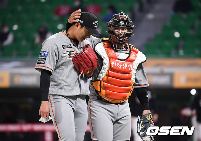 한화 포수 최재훈(오른쪽)이 투수 김이환과 이야기하며 더그아웃으로 들어가고 있다. /OSEN DB