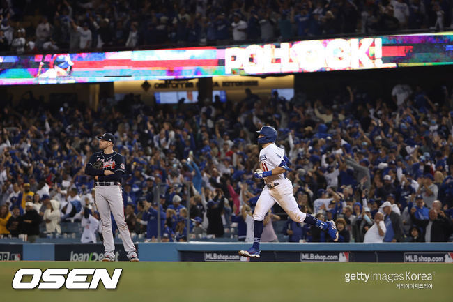 [사진] LA 다저스의 AJ 폴락(오른쪽)이 22일(한국시간) 다저스타디움에서 벌어진 애틀랜타와의 NLCS 5차전 8회서 승부의 쐐기를 박는 3점 홈런을 친 뒤 관중들의 환호성을 받으며 1루 베이스를 돌고 있다. ⓒGettyimages(무단전재 및 재배포 금지)