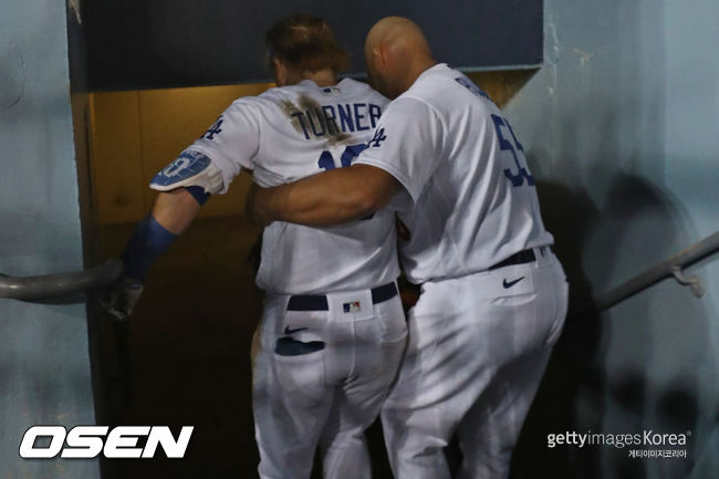 [사진] 다저스 알버트 푸홀스(오른쪽)가 4차전에서 햄스트링 부상을 당한 저스틴 터너를 부축하고 있다. ⓒGettyimages(무단전재 및 재배포 금지)