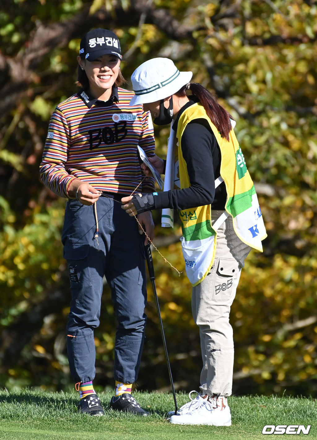 1번홀 박주영이 그린에서 바지 끈의 올이 풀려 캐디로 나선 언니 박희영의 도움을 받고 있다.  2021.11.07 /jpnews@osen.co.kr