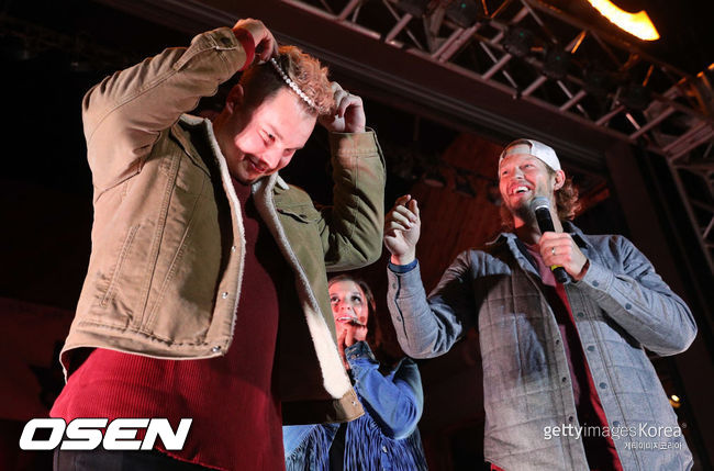 [사진] 작 피더슨(왼쪽)이 12일(한국시간) 텍사스주 댈러스에서 열렸던 KC 라이브에 참석해 즉석 경매를 위해 진주 목걸이를 빼고 있다. 오른쪽은 주최자인 클레이튼 커쇼와 그의 부인 엘렌(가운데) .ⓒGettyimages(무단전재 및 재배포 금지)