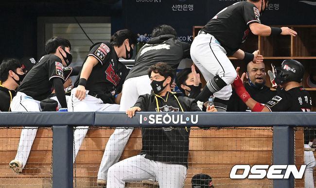 18일 오후 서울 고척스카이돔에서 두산 베어스와 KT 위즈의 2021시즌 KBO리그 한국시리즈 4차전이 열렸다.1회초 2사 1,3루에서 KT 장성우의 좌중간 적시타 때 박경수가 더그아웃에서 홈을 밟은 황재균을 축하하고 있다. 2021.11.18 /sunday@osen.co.kr