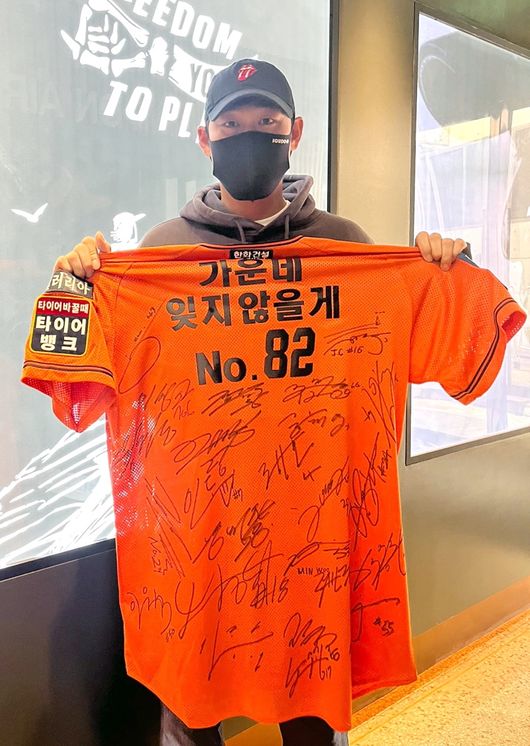 한화 하주석이 조니 워싱턴 코치에게 선물한 유니폼을 들어보이고 있다. /한화 이글스 제공