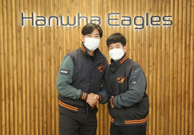 한화 정민철 단장과 최재훈(오른쪽)이 FA 계약 후 악수를 하고 있다. /한화 이글스 제공