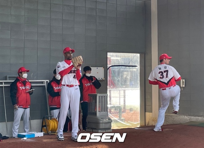 로니와 놀린이 불펜에서 함께 피칭을 하고 있다.