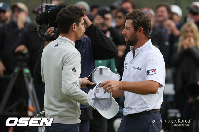 [사진] 카메론 영이 21일(한국시간) 리비에라 컨트리클럽에서 벌어진 제네시스 인비테이셔널 4라운드 18번 홀 그린에서 우승한 호아킨 니에만과 악수를 나누고 있다. 영의 왼 팔뚝에 메이저리그 로고가 선명하게 보인다.ⓒGettyimages(무단전재 및 재배포 금지)