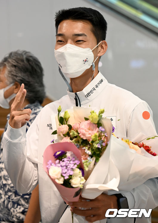 3일 오후 인천공항 제2터미널을 통해 2020 도쿄올림픽을 마친 국가대표 선수들이 귀국했다.도쿄올림픽 육상 높이뛰기 우상혁이 기념촬영을 하고 있다. 2021.08.03 /ksl0919@osen.co.kr