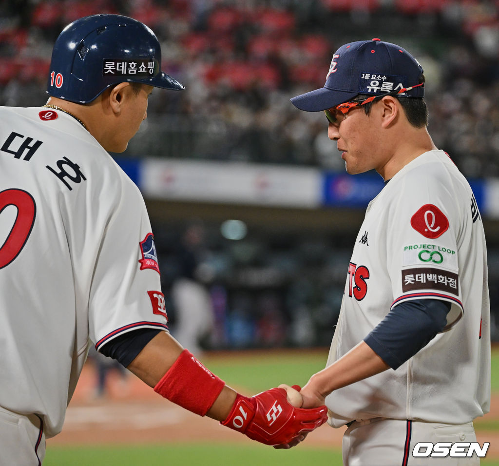 박세웅이 5회 4실점하고 7회를 마친 후 더그아웃으로 돌아오자 이대호가 손을 꼭 잡고 있다.