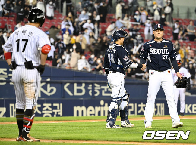 4일 경기를 마치고 세이브를 거둔 두산 투수 김강률과 포수 박세혁이 인사를 나누고 있다. 3루수 직선타로 아웃되며 아쉬워하는 LG 타자는 박해민. 2022.05.04 / dreamer@osen.co.kr