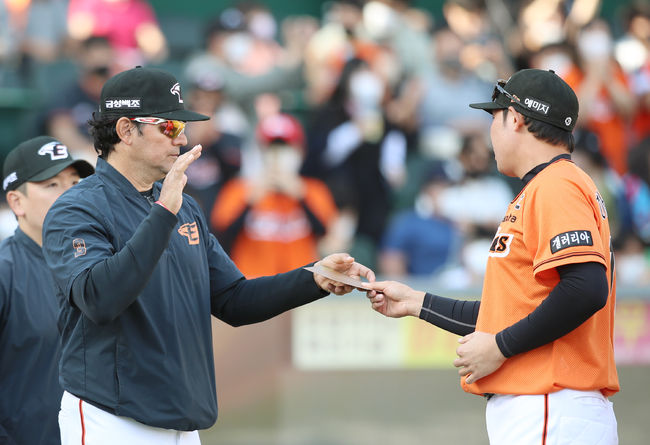 한화 수베로 감독(왼쪽)이 승리 후 주장 하주석으로부터 스승의 날 기념 상품권을 선물로 받고 있다. /한화 이글스 제공