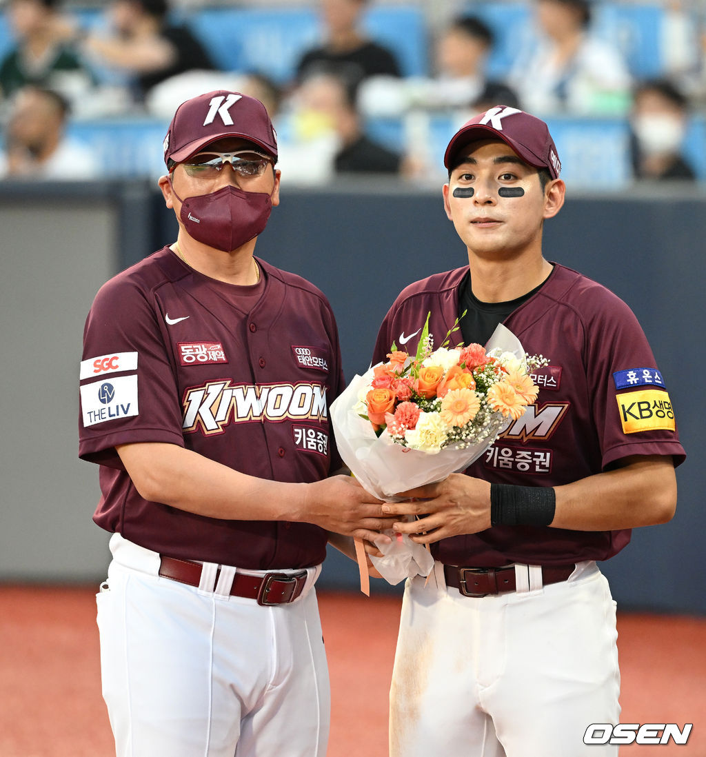 28일 오후 경기도 수원 KT위즈파크 2022 신한은행 SOL KBO 리그 KT 위즈와 키움 히어로즈의 경기가 열렸다.4회말 공수교대 때 역대 최연소 1000안타를 기록한 키움 이정후가 홍원기 감독으로부터 꽃다발을 받고 있다. 2022.07.28 /sunday@osen.co.kr