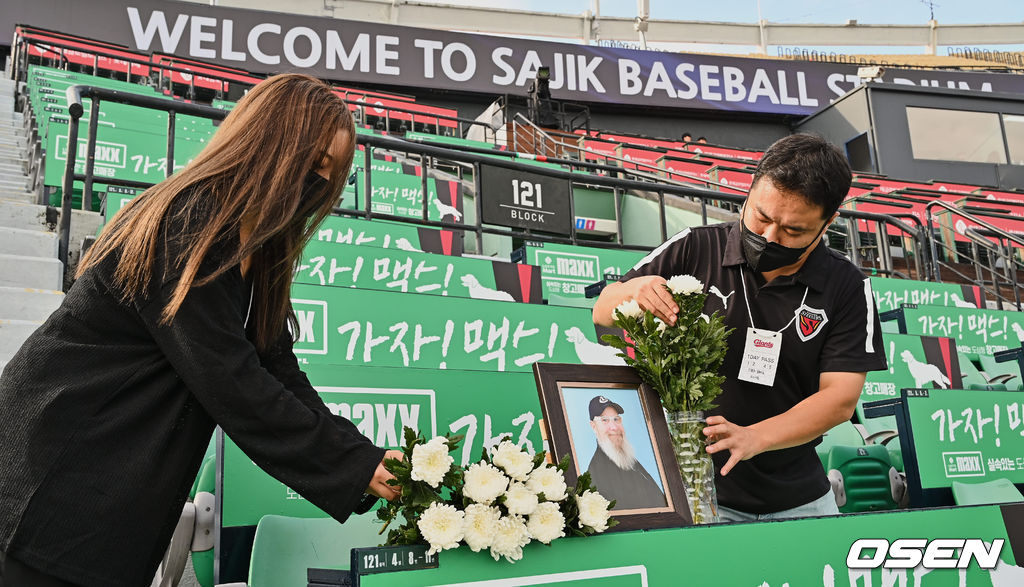 17일 부산 사직구장에서 ‘2022 신한은행 SOL KBO리그’ 롯데 자이언츠와 두산 베어스의 경기가 열린다. ‘사직 할아버지’ 캐리 마허 전 교수의 별세 소식을 접한 롯데팬들이 고인이 늘 앉던 사직구장 테이블석에 사진과 조화로 추모 공간을 만들고 있다. 2022.08.17 / foto0307@osen.co.kr