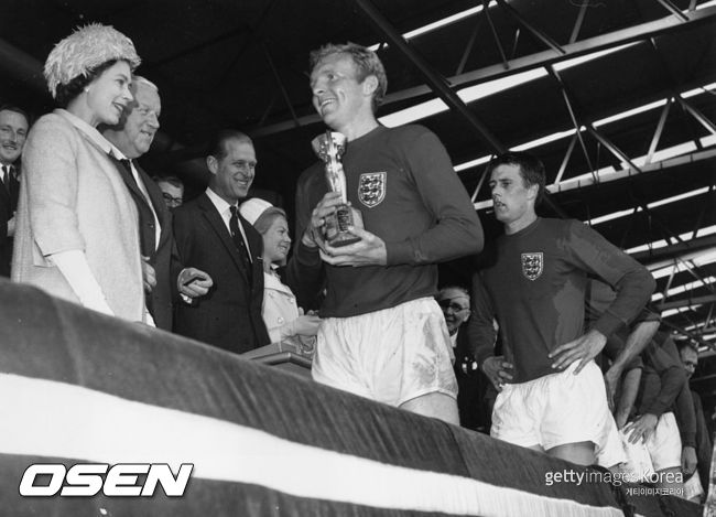 [사진] 잉글랜드가 처음이자 마지막으로 우승한 1966년 잉글랜드 월드컵 때 엘리자베스 여왕으로부터 주장 보비 무어가 줄리메컵(브라질이 3회 우승 후 영구 소유해 현재와 다른 우승컵)을 받고 있는 모습 ⓒGettyimages(무단전재 및 재배포 금지)