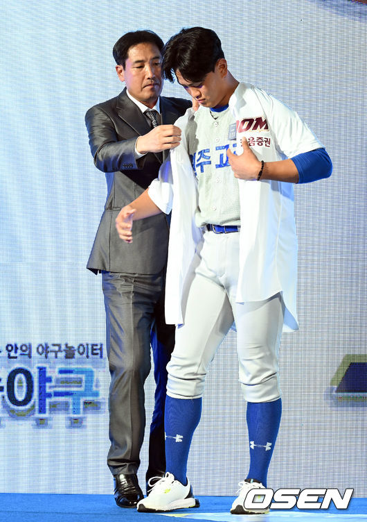 2023 KBO 신인 드래프트가 15일 오후 서울 웨스틴조선호텔 그랜드볼룸에서 열렸다.KBO 신인 드래프트는 1라운드부터 10라운드까지 진행되며 지명 순서는 2021년 팀순위의 역순인 한화 이글스-KIA 타이거즈-롯데 자이언츠-NC 다이노스-SSG 랜더스-키움 히어로즈-LG 트윈스-삼성 라이온즈-두산 베어스-KT 위즈 순으로 지명이 이뤄진다. 1차 지명된 키움 김건희(원주고)에게 고형욱 단장이 유니폼을 입혀주고 있다. 2022.09.15 /cej@osen.co.kr