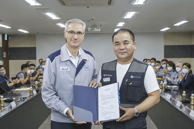 로베르토 렘펠 한국지엠 사장(왼쪽)과 금속노조 한국지엠지부 김준오 지부장이 2022년 임단협 교섭 합의안에 대한 조인식을 갖고 기념 촬영을 하고 있다.