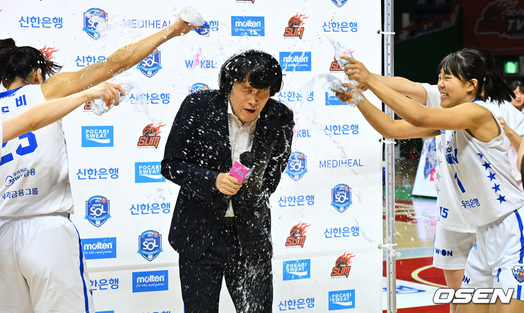 정규리그 우승을 차지한 아산 우리은행 선수들이 방송 인터뷰 중인 위성우 감독에게 축하 물세례를 하고 있다. 