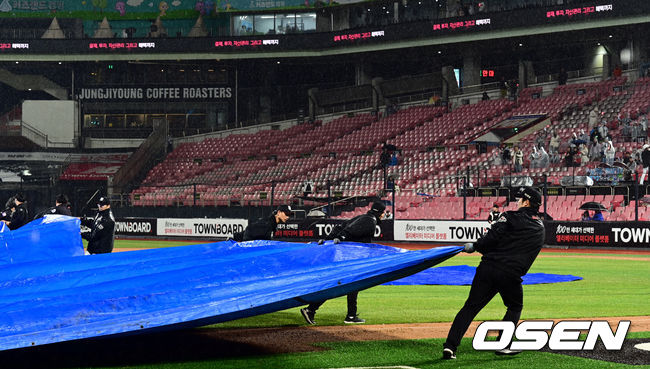 4일 오후 경기 수원시 수원KT위즈파크에서 ‘2023 신한은행 SOL KBO리그’ KT 위즈와 KIA 타이거즈의 경기가 열렸다.4회말 시작을 앞두고 우천으로 경기가 잠시 중단됐다. 그라운드에 방수포가 덮이고 있다. 2023.04.04 /cej@osen.co.kr