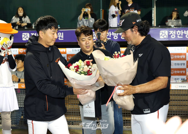 한화 수베로 감독(오른쪽)이 통산 100승을 거둔 뒤 주장 정우람으로부터 축하 꽃다발을 받고 있다. /한화 이글스 제공