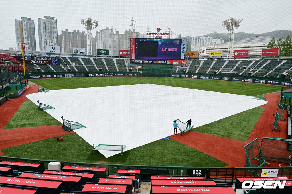 6일 부산 사직구장에서 2023 신한은행 SOL KBO리그 롯데 자이언츠와 삼성 라이온즈의 경기가 열린다. 5일 어린이날에 이어 6일에도 아침부터 계속된 비와 강한 바람으로 사직야구장 관계자들이 방수포가 바람에 날아가지 않게 작업을 하고 있다. 2023.05.06 / foto0307@osen.co.kr