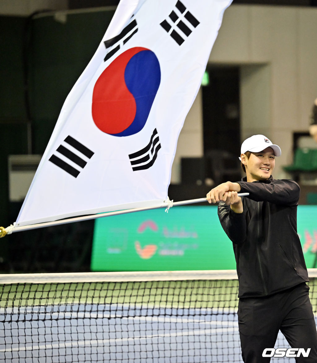 극적인 대역전승을 거둔 한국 남자 테니스가 2년 연속 데이비스컵 16강에 진출했다.박승규 감독이 이끄는 한국남자테니스대표팀이 5일 서울 송파구 올림픽공원 실내 테니스경기장에서 열린 2023 데이비스컵 최종본선 진출전(4단1복식) 둘째 날 복식과 3, 4단식을 잇달아 벨기에를 꺾었다. 전날 기록한 0-2에서 3-2로 리버스 스윕에 성공한 한국은 본선 무대인 16강에 진출했다. 다섯 번째 16강으로, 사상 첫 2년 연속 진출이다. 권순우가 경기를 마치고 태극기를 휘날리고 있다. 2023.02.05 / rumi@osen.co.kr