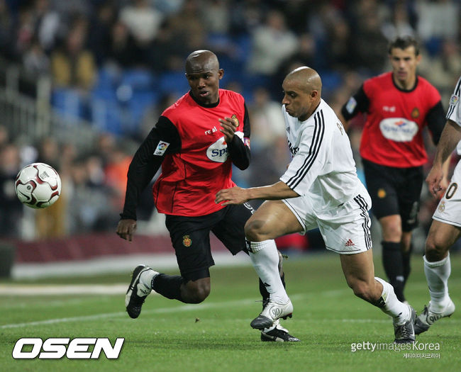 MADRID, SPAIN - MAY 8:  Samuel Etoo of Real Mallorca tussles with Roberto Carlos of Real Madrid  during the Spanish Primera Liga match between Real Madrid and Real Mallorca at The Santiago Bernabeu Stadium on May 8, 2004 in Madrid, Spain.  (Photo by Shaun Botterill/Getty Images) *** Local Caption *** Samuel Etoo;Roberto Carlos