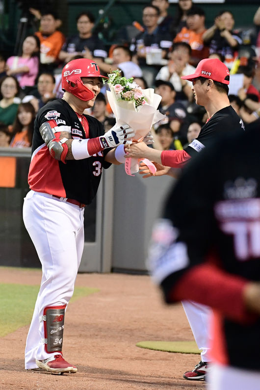 KIA 최형우(왼쪽)가 1500타점 기록을 달성한 뒤 김종국 감독으로부터 축하 꽃다발을 받고 있다. /KIA 타이거즈 제공