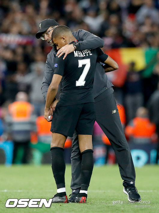 Liverpool manager Jurgen Klopp (back) with Paris Saint-Germain's Kylian Mbappe after the final whistle<br />