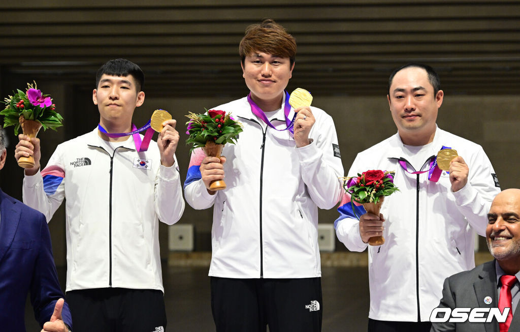 26일 오전 중국 푸양 인후 스포츠센터에서 '제19회 항저우아시안게임' 사격 러닝 타겟 10m 혼합 개인전 및 단체전 경기가 열렸다. 이날 경기에서 하광철, 정유진, 곽용빈이 총점 1116점을 기록, 금메달을 목에 걸었다.경기 종료 후 금메달을 수상한 한국 대표팀 선수들이 취재진을 향해 포즈를 취하고 있다. 2023.09.26 / ksl0919@osen.co.kr