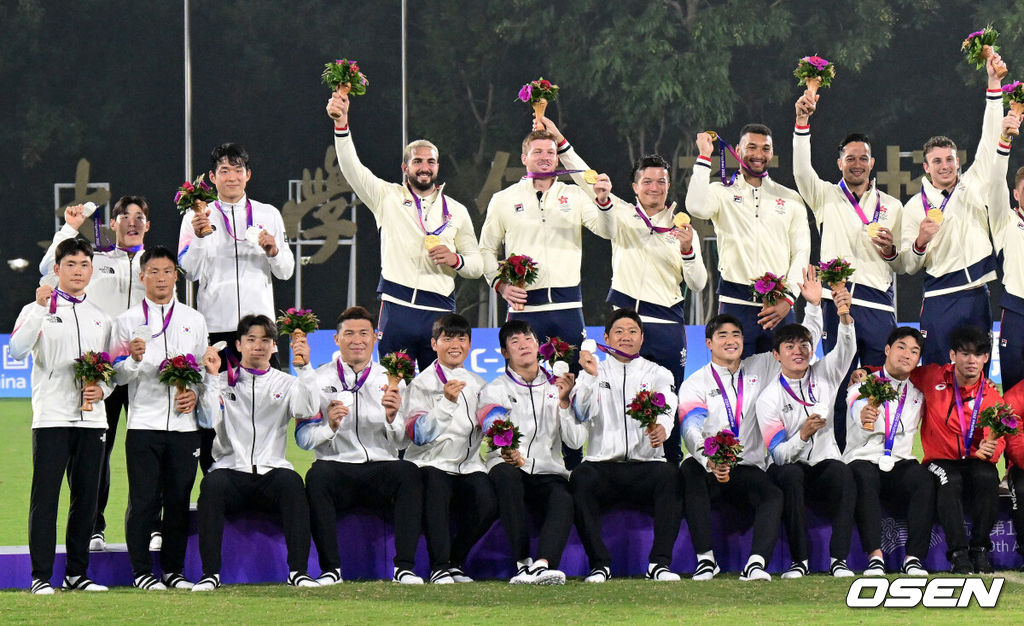 26일 오후(한국시간) 중국 항저우 항저우사범대 창첸 캠퍼스 경기장에서 열린 ‘2022 항저우 아시안게임’ 7인제 럭비 결승 대한민국과 홍콩의 경기, 한국이 7-14로 패하며 은메달을 차지했다.금메달 홍콩, 은메달 대한민국, 동메달 일본 선수들이 모두 모여 포즈를 취하고 있다. 2023.09.26 / dreamer@osen.co.kr