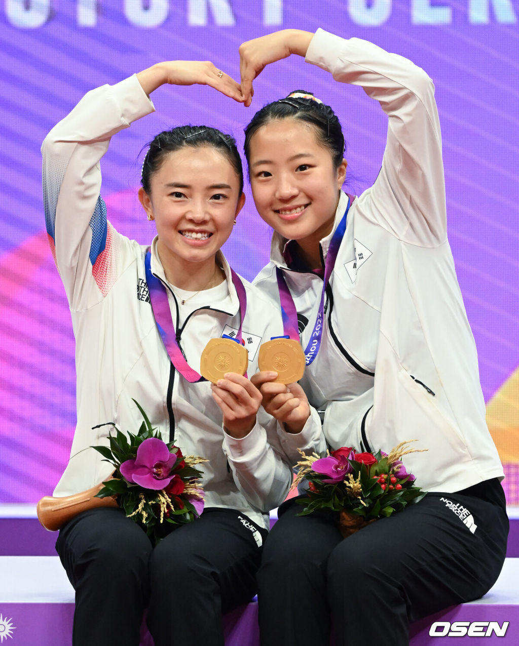 33년 만에 결승전에서 북한을 만난 한국 여자 탁구 전지희-신유빈 조가 이들을 꺾고 21년 만에 금메달을 목에 걸었다.전지희-신유빈 조는 2일(한국시간) 중국 항저우 궁수 캐널 스포츠파크 체육관에서 열린 2022 항저우 아시안게임 탁구 여자복식 결승전에서 북한의 차수영-박수경 조와 맞대결을 펼쳐 4-1(11-6, 11-4, 10-12, 12-10, 11-4)로 승리했다.경기 종료 후 대한민국 전지희, 신유빈이 시상대에서 세리머니를 하고 있다. 2023.10.02 / ksl0919@osen.co.kr