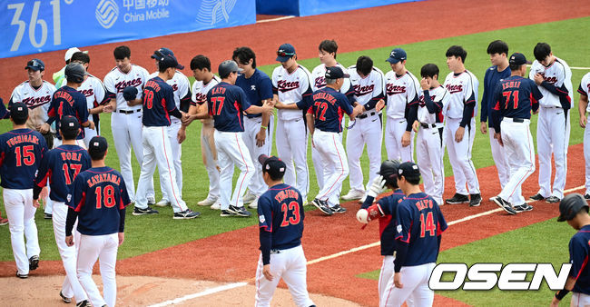 한국이 숙적 일본을 꺾고 슈퍼라운드 1차전을 승리로 장식했다. 한국은 5일(이하 한국시간) 중국 저장성 사오싱 야구장에서 열린 2022 항저우 아시안게임 슈퍼라운드 일본전에서 2-0으로 이겼다. 선발 박세웅의 완벽투를 앞세워 승리를 거머쥐었다. 경기를 마치고 양 팀 선수들이 인사를 나누고 있다. 2023.10.05 / dreamer@osen.co.kr