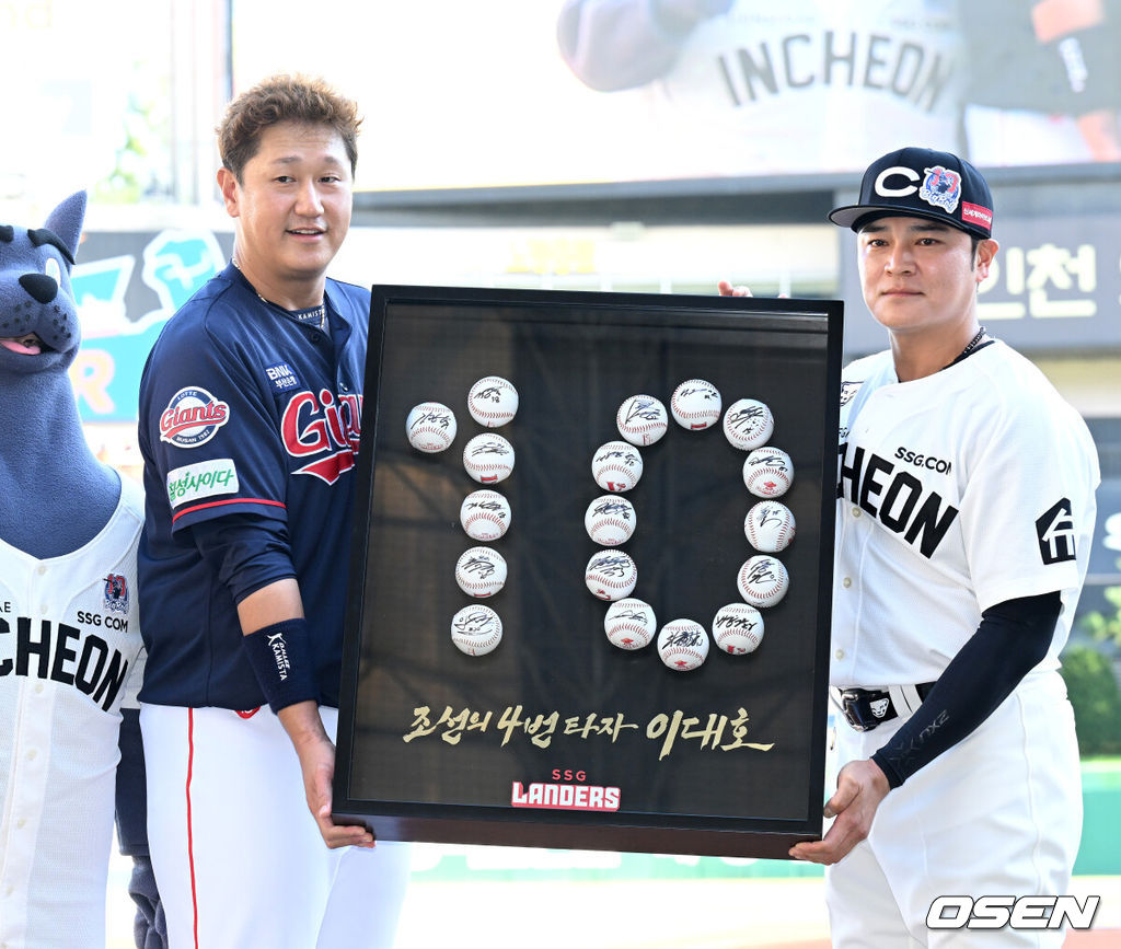 28일 오후 인천 SSG 랜더스필드에서 2022 신한은행 SOL KBO 리그 SSG 랜더스와 롯데 자이언츠의 경기가 열렸다.경기에 앞서 열린 롯데 이대호의 은퇴투어 행사에서 SSG 추신수가 이대호에게 기념액자를 전달하고 포즈를 취하고 있다. /2022.08.28 /sunday@osen.co.kr