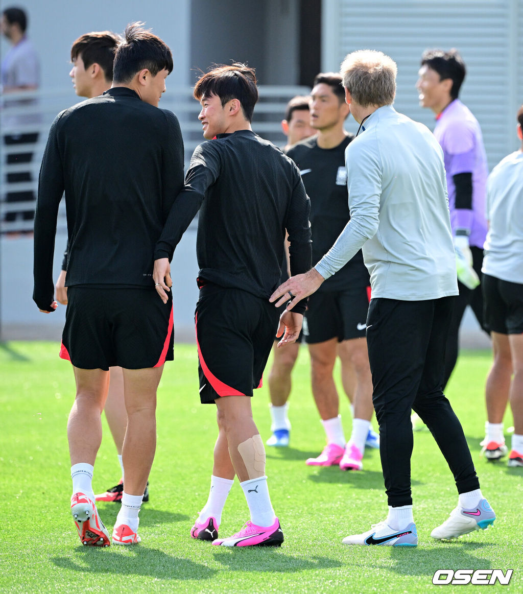 대한민국 축구대표팀이 18일(현지시간) 카타르 도하 알 에글라 트레이닝 센터에서 훈련을 가졌다.김진수가 훈련을 준비하며 김민재, 클린스만 감독과 이야기를 나누고 있다. 2024.01.18 / jpnews.osen.co.kr