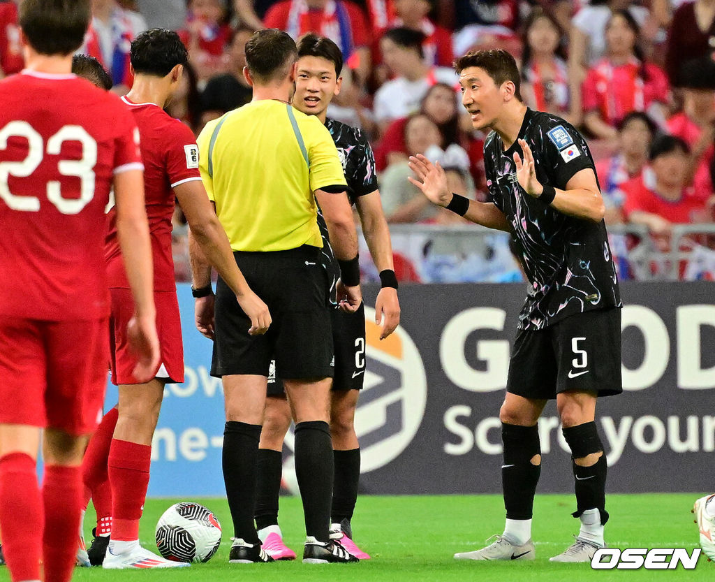 김도훈 임시감독이 이끄는 대한민국과 싱가포르의 2026 FIFA 북중미 월드컵 아시아 2차 예선 C조 5차전이 6일(한국시간) 오후 9시 싱가포르 칼랑에 위치한 싱가포르 더 내셔널 스타디움에서 열렸다.각 조 1・2위에 3차 예선 진출 자격이 주어지는 가운데 한국은 싱가포르와 5차전에서 비기기만 해도 11일 중국과 6차전 경기 결과와 상관없이 3차 예선행을 확정한다. 심지어 5차전에서 한국이 패해도 태국이 승점을 챙기지 못한다면 3차 예선으로 향할 수 있다.전반 반칙을 한 대한민국 정우영이 굴무로디 사둘로 주심과 이야기를 나누고 있다. 2024.06.06 /cej@osen.co.kr