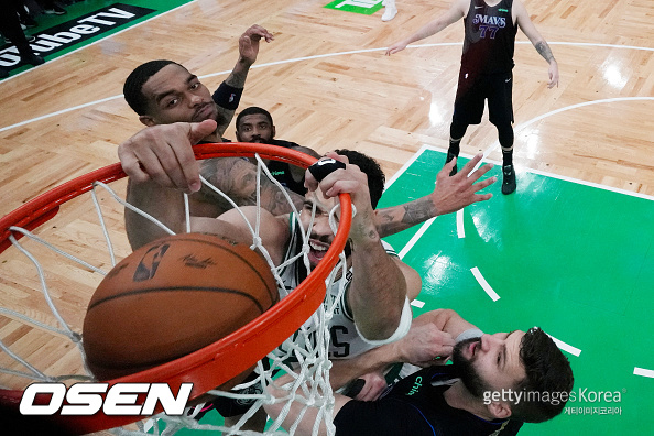 Jun 6, 2024; Boston, Massachusetts, USA; Boston Celtics forward Jayson Tatum (0) dunks the ball against Dallas Mavericks forward Derrick Jones Jr. (left) and forward Maxi Kleber (right) during the second quarter of game one of the 2024 NBA Finals at TD Garden. Mandatory Credit: Peter Casey-USA TODAY Sports