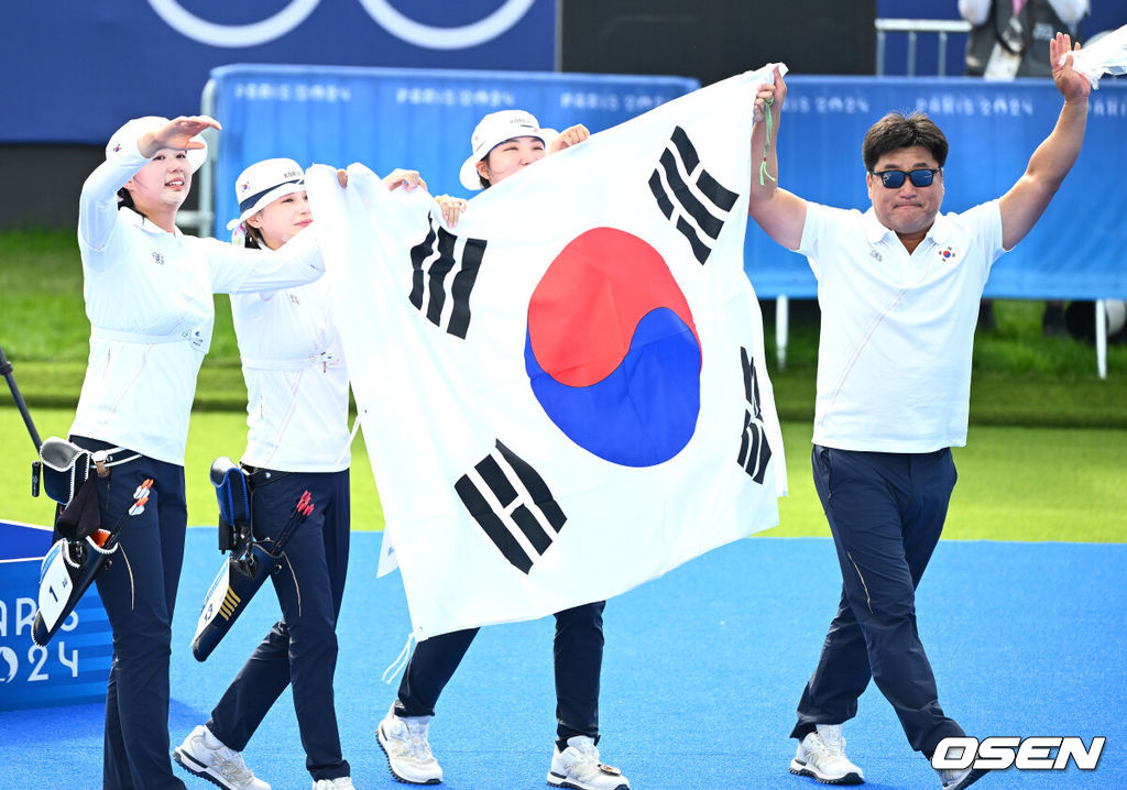 한국 여자 양궁이 올림픽 10연패 대기록을 쐈다.임시현(한국체대), 남수현(순천시청), 전훈영(인천시청)으로 구성된 한국 양궁 대표팀은 프랑스 파리 앵발리드에서 열린 ‘2024 파리올림픽’ 양궁 여자 리커브 단체전 결승서 중국(안치쉬안, 리지아만, 양사오레이) 상대로 5-4(56-53, 55-54, 51-54, 53-55, )로 승리하면서 대회 10연패를 달성했다.금메달을 거머쥔 임시현, 남수현, 전훈영과 양창훈 감독이 태극기를 펼치며 기뻐하고 있다. 2024.07.29 / dreamer@osen.co.kr