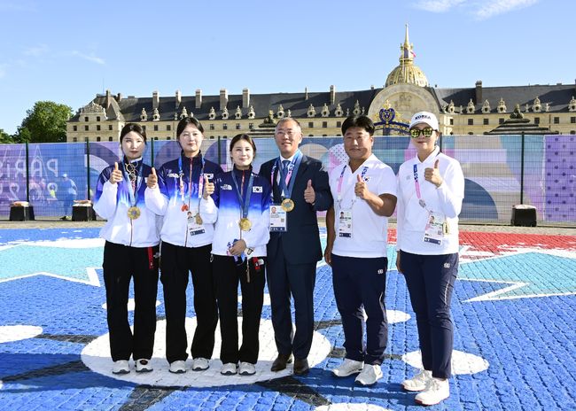 현대차그룹 정의선 회장이 여자 양궁 단체 국가대표 선수들(왼쪽부터 남수현, 임시현, 전훈영), 코치진(왼쪽부터 양창훈 감독, 김문정 코치)과 기념 촬영을 하고 있다. /대한양궁협회 제공