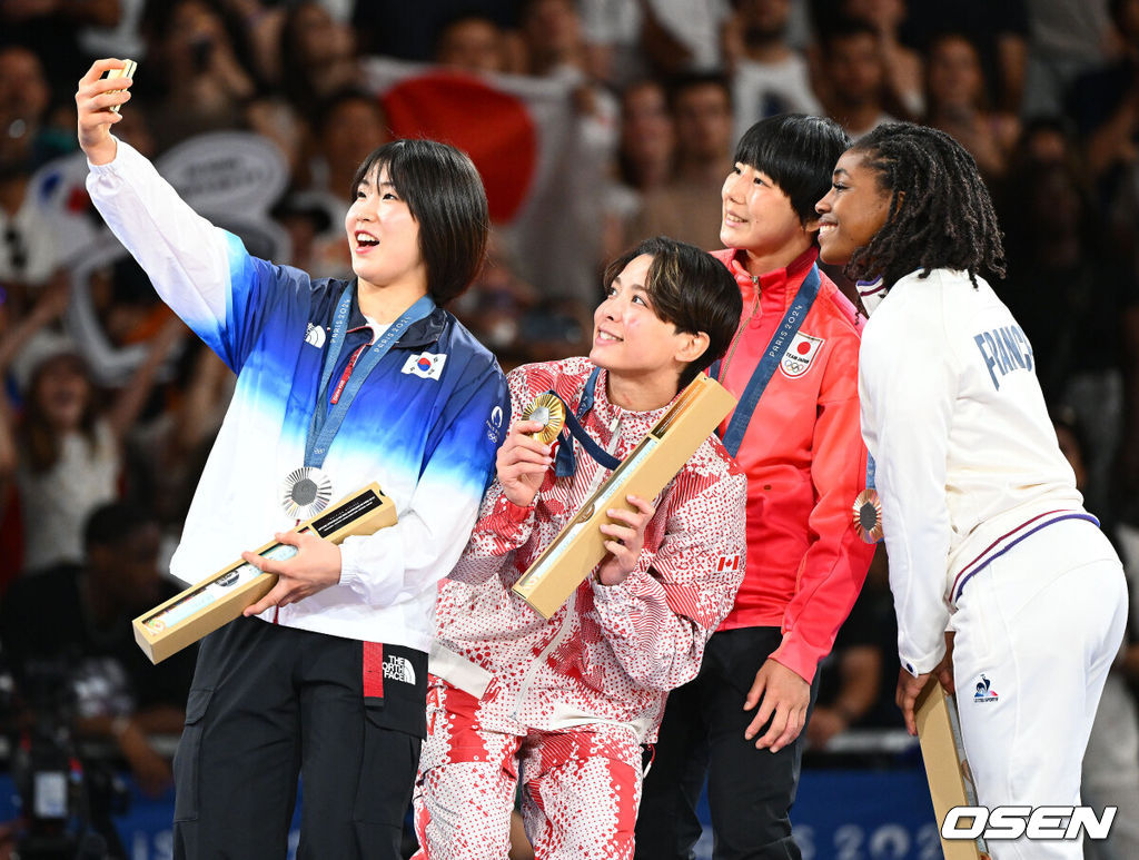 30일(한국시간) 프랑스 파리 샹드마르스 아레나에서 ‘2024 파리올림픽’ 여자 유도 57kg 결승 한국 허미미와 캐나다 크리스티안 데구치의 경기가 열렸다.허미미(22, 세계 랭킹 3위)는 크리스티안 데구치(캐나다, 세계 랭킹 1위)에게 골든 스코어 끝에서 연장전서 지도 3개로 반칙패를 당하면서 은메달을 획득했다.허미미가 금메달을 딴 캐나다 데구치, 동메달 일본 후나쿠보, 프랑스 시지케와 함께 시상대에 올라 기념 사진을 찍고 있다. 2024.07.30 / dreamer@osen.co.kr