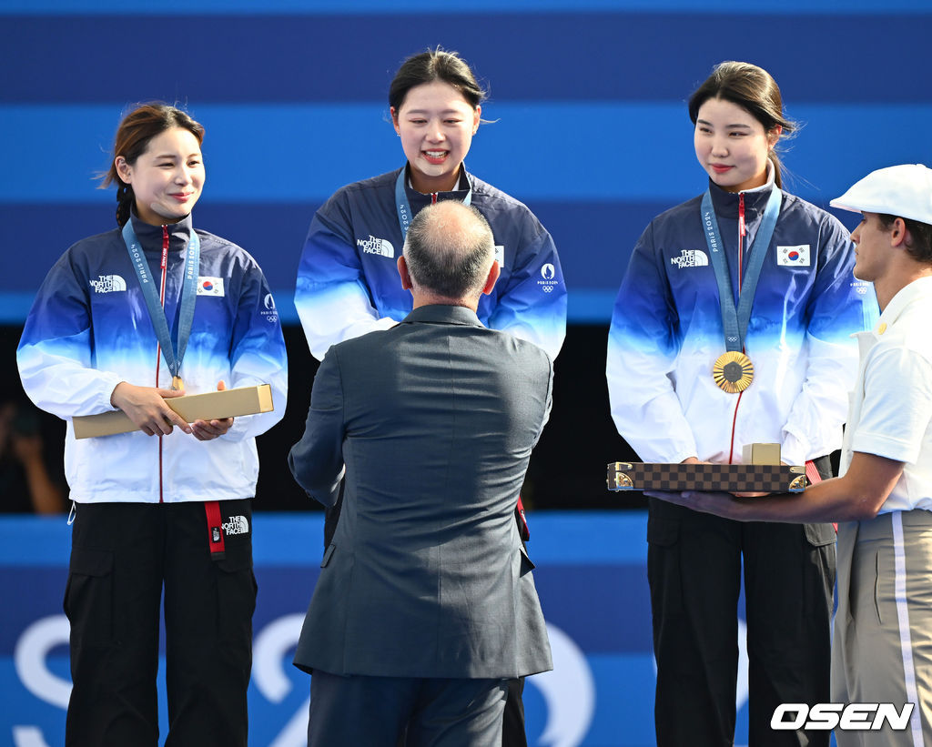 한국 여자 양궁이 올림픽 10연패 대기록을 쐈다.<br /><br />임시현(한국체대), 남수현(순천시청), 전훈영(인천시청)으로 구성된 한국 양궁 대표팀은 프랑스 파리 앵발리드에서 열린 ‘2024 파리올림픽’ 양궁 여자 리커브 단체전 결승서 중국(안치쉬안, 리지아만, 양사오레이) 상대로 5-4(56-53, 55-54, 51-54, 53-55, 29-27)로 승리하면서 대회 10연패를 달성했다.<br /><br />금메달을 거머쥔 한국 임시현-남수현-전훈영이 시상자로 나선 정의선 현대차 회장에게 기념품을 받고 있다. 2024.07.29 / dreamer@osen.co.kr<br />