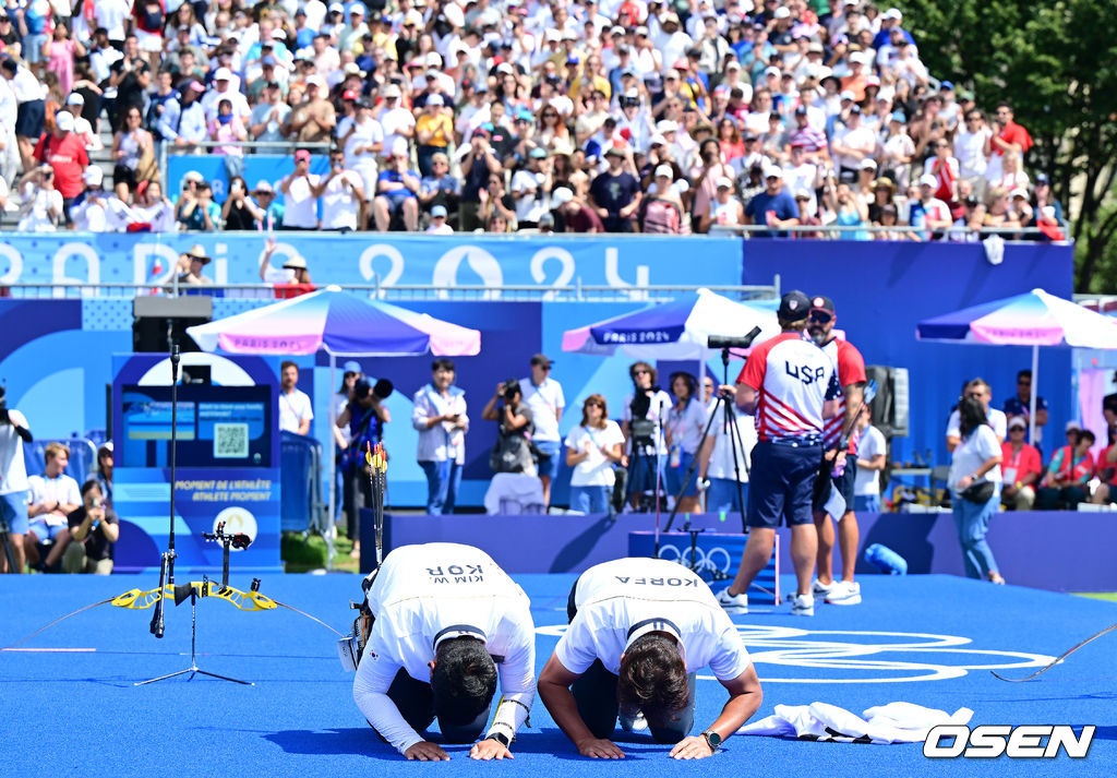 4일(한국시간) 프랑스 파리 레쟁발리드에서 ‘2024 파리올림픽’ 양궁 남자 리커브 개인 금메달결정전 한국 김우진과 미국 브래들리 엘리슨의 경기가 열렸다.김우진은 마지막 슛오프 끝에 금메달을 거머쥐었다.금메달 김우진이 박성수 감독과 관중석을 향해 절하고 있다. 2024.08.04 / dreamer@osen.co.kr